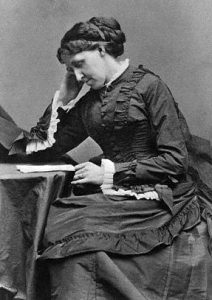 photograph of Louisa May Alcott writing
